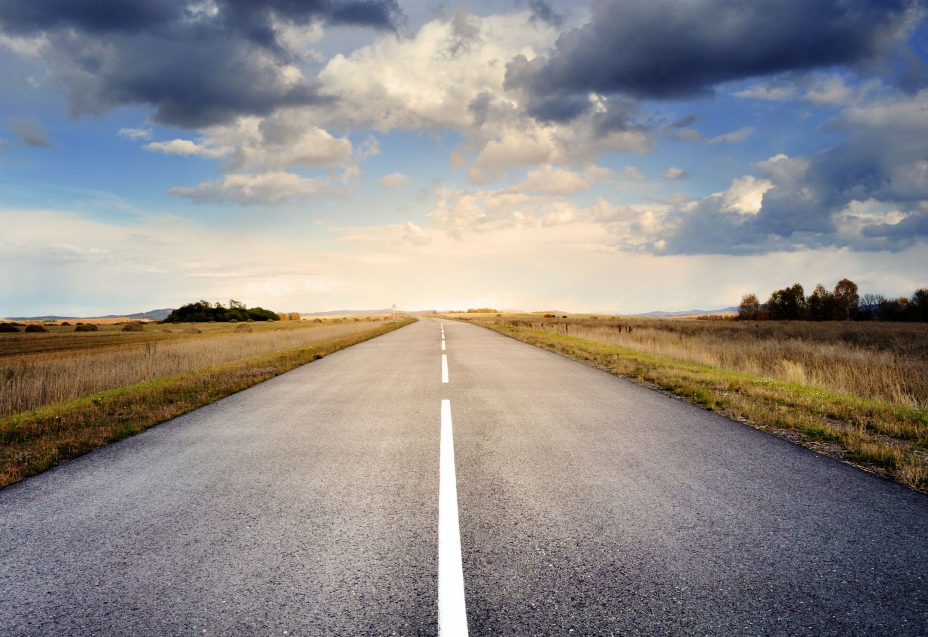 asphalt road under cloudy sky
